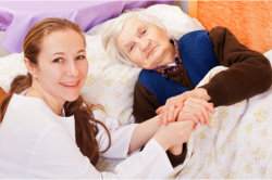elderly woman on bed with her caregiver